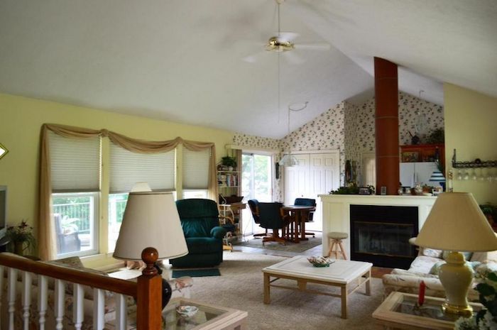 Main living room before renovation; yellow walls with red and brown accents. 