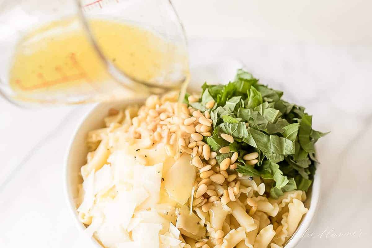 pouring vinaigrette on pasta salad