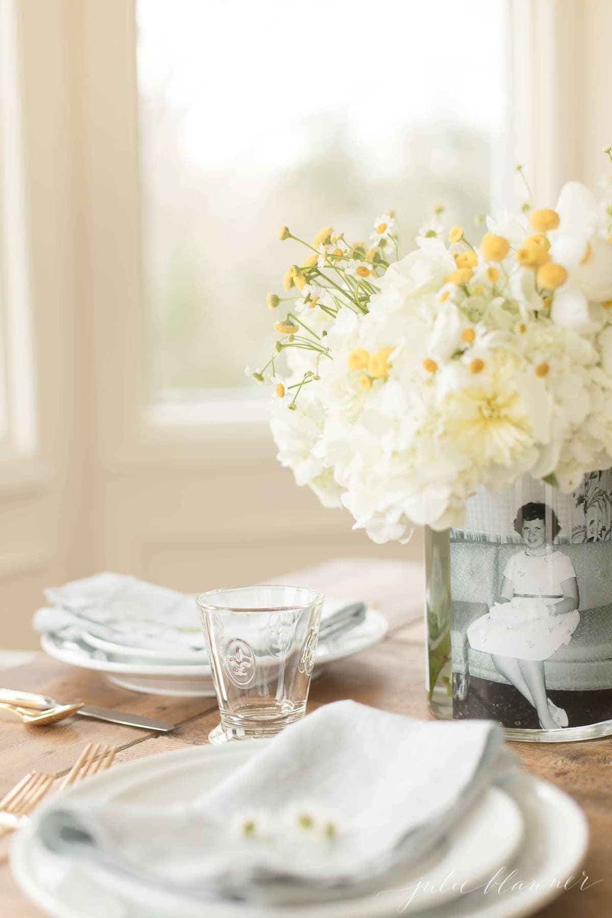 mother's day photo centerpiece on table set with white dishes and glassware