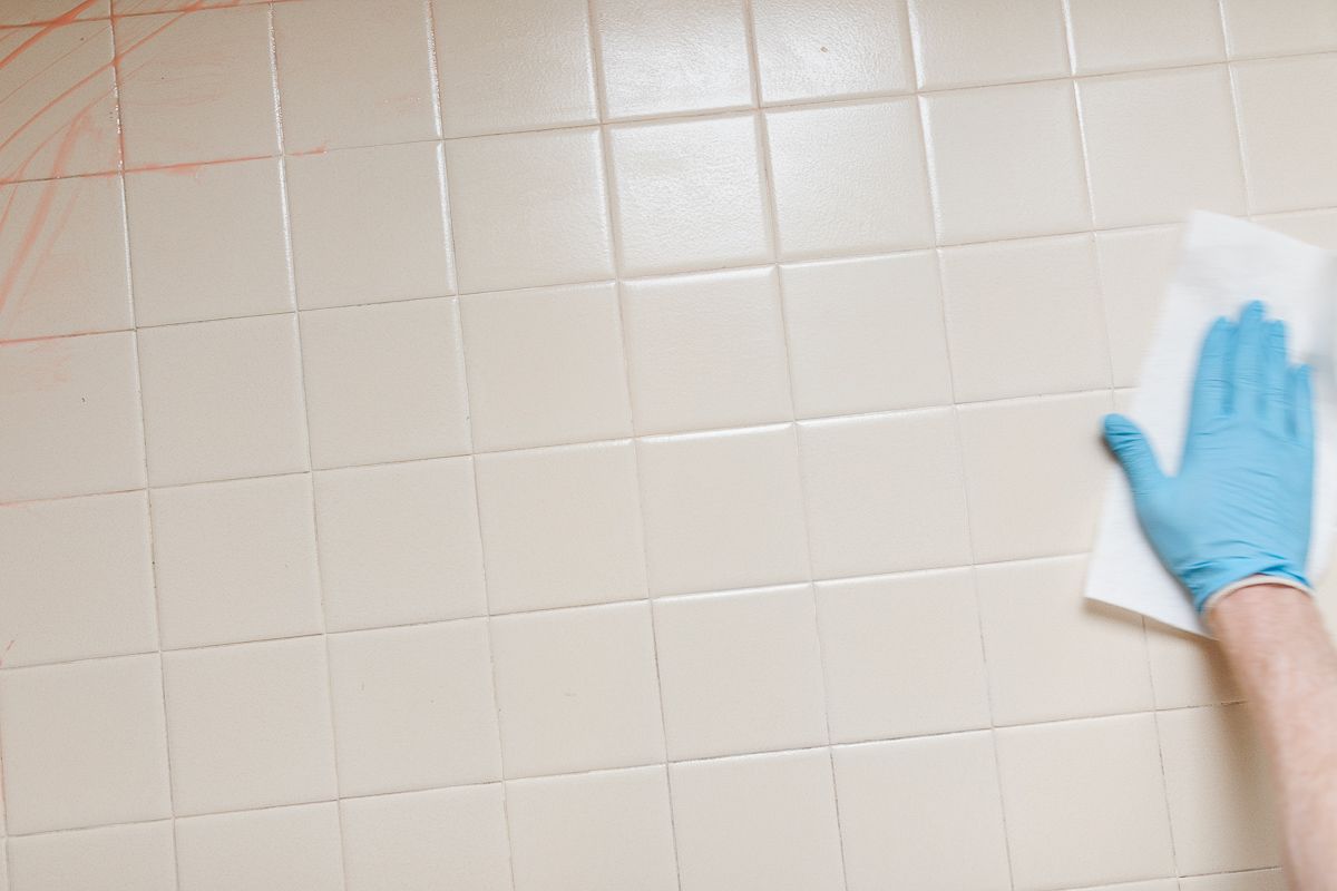 Old tiles with citrus stripper being wiped away for a tile paint project