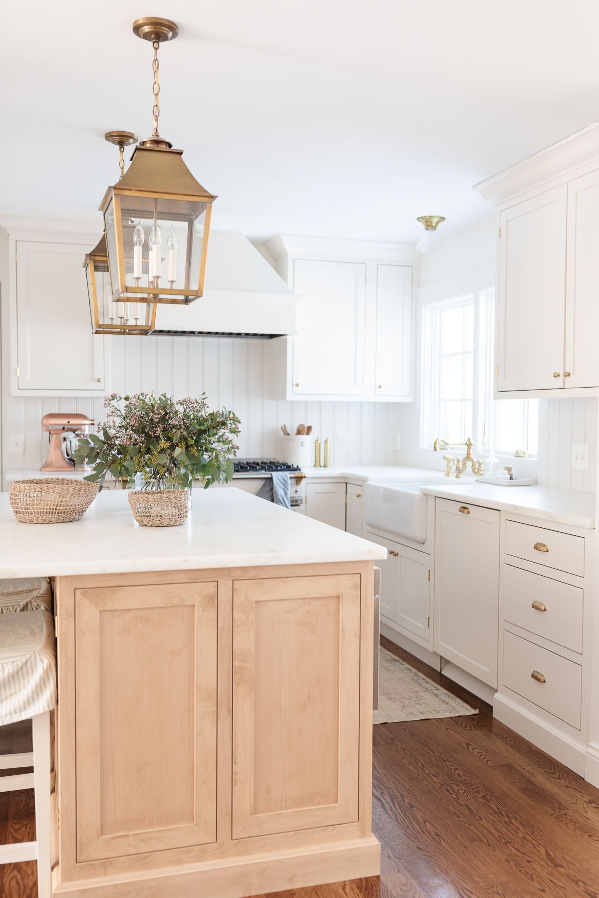 Two brass lantern pendants hanging over a kitchen island