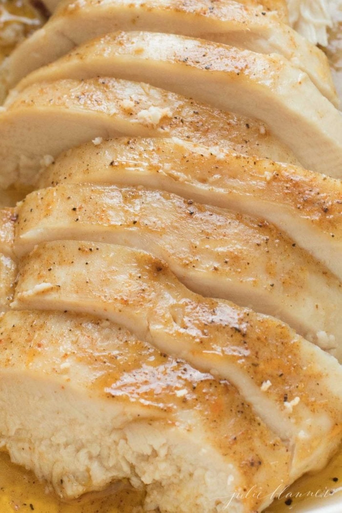 oven baked chicken breast sliced in a white baking dish.