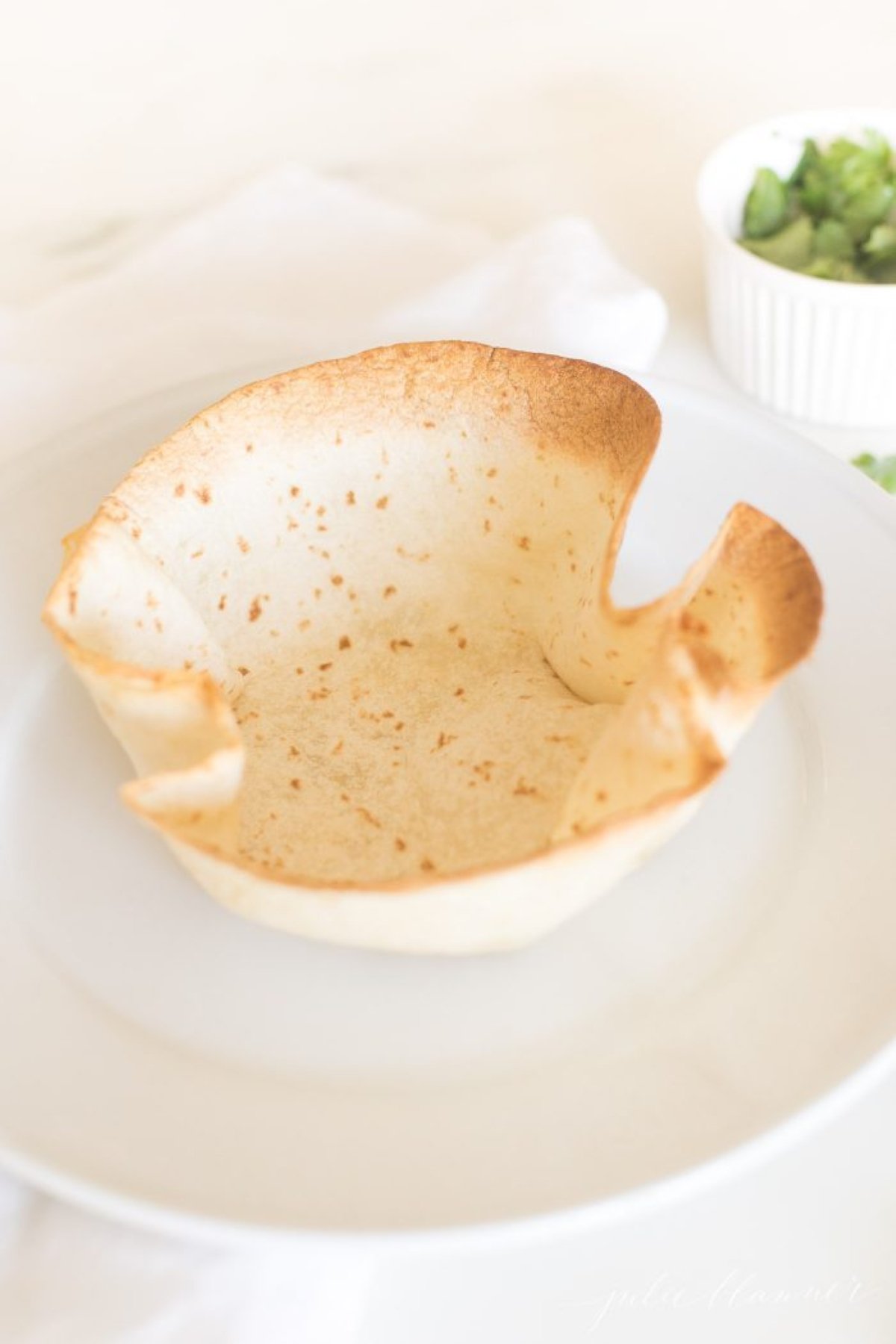 A taco salad bowl on a white plate.