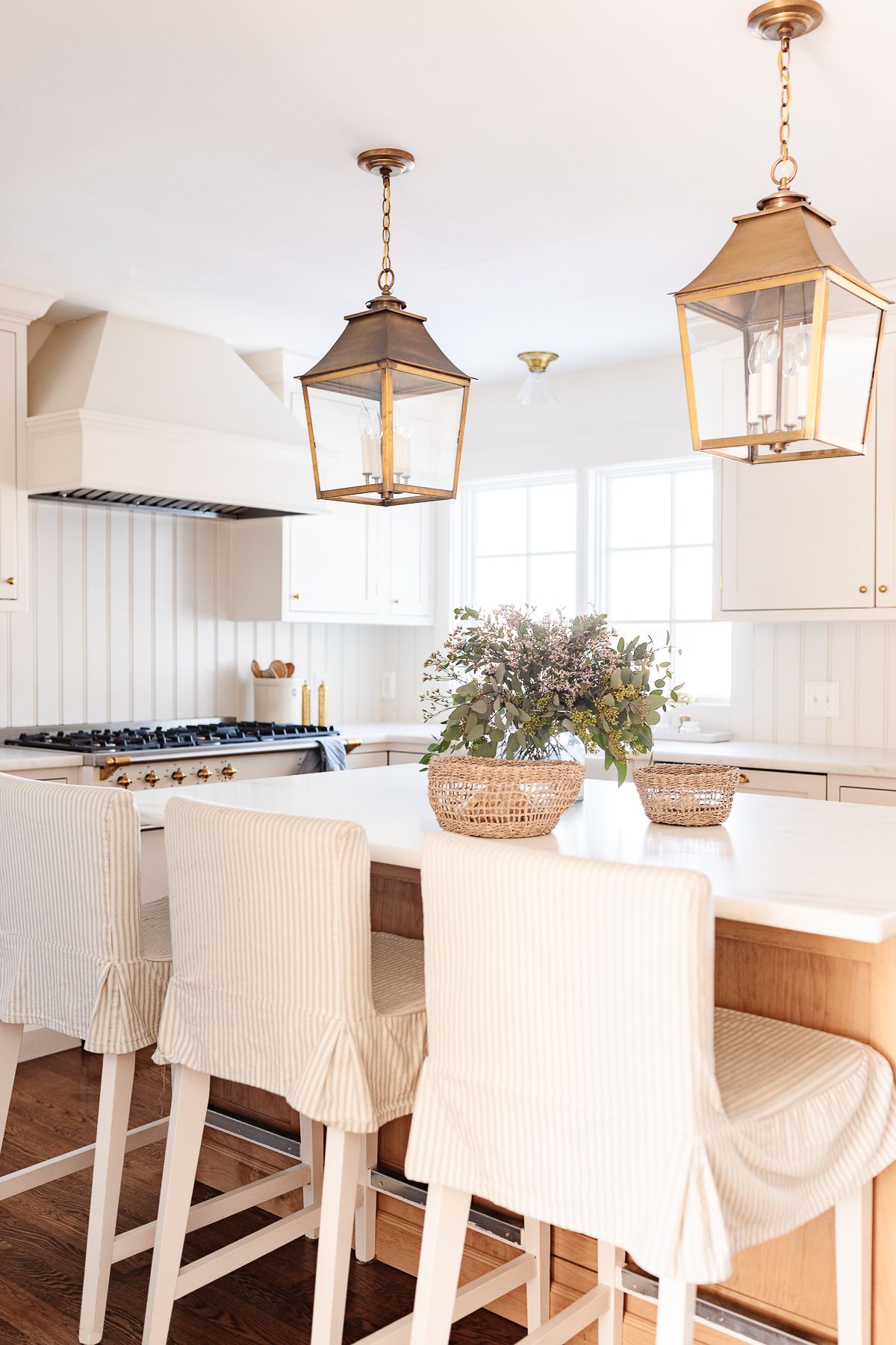 Two brass lantern pendants hanging over a kitchen island