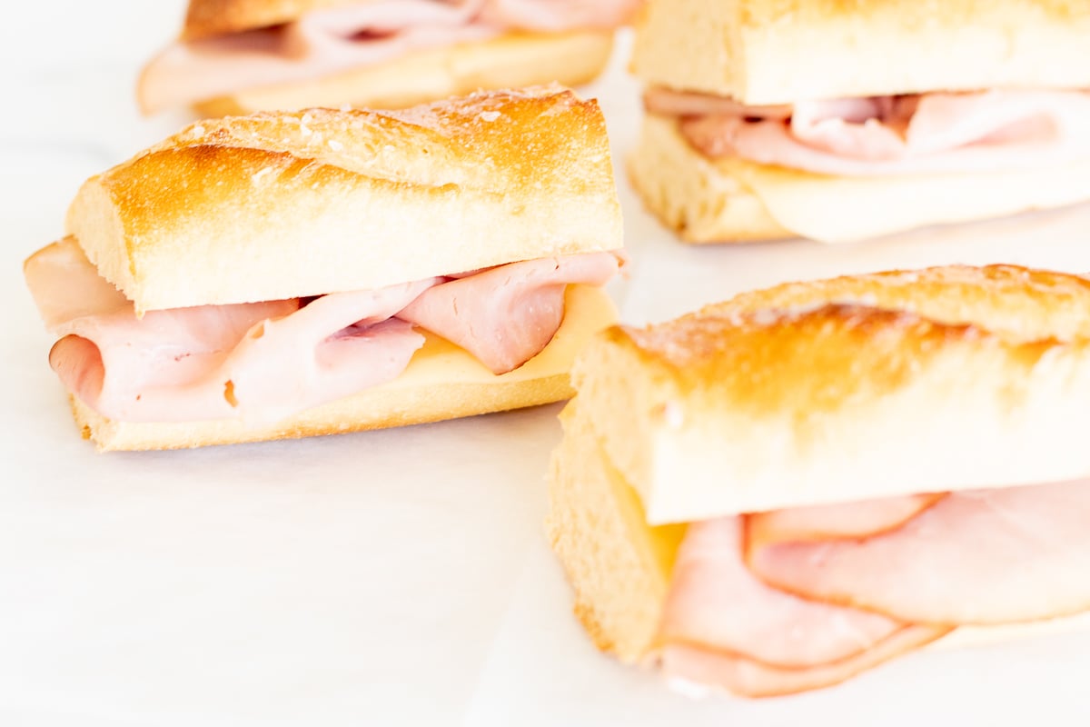 Picnic sandwiches on a white surface.