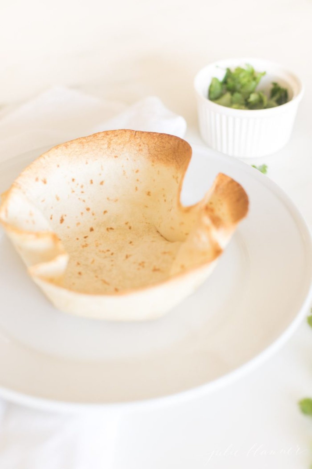 A taco salad bowl on a white plate.