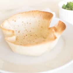 A taco salad bowl on a white plate.