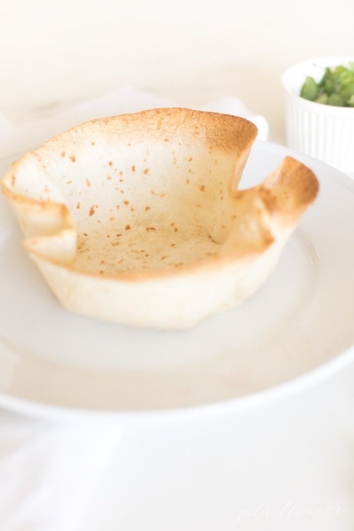 A taco salad bowl on a white plate.