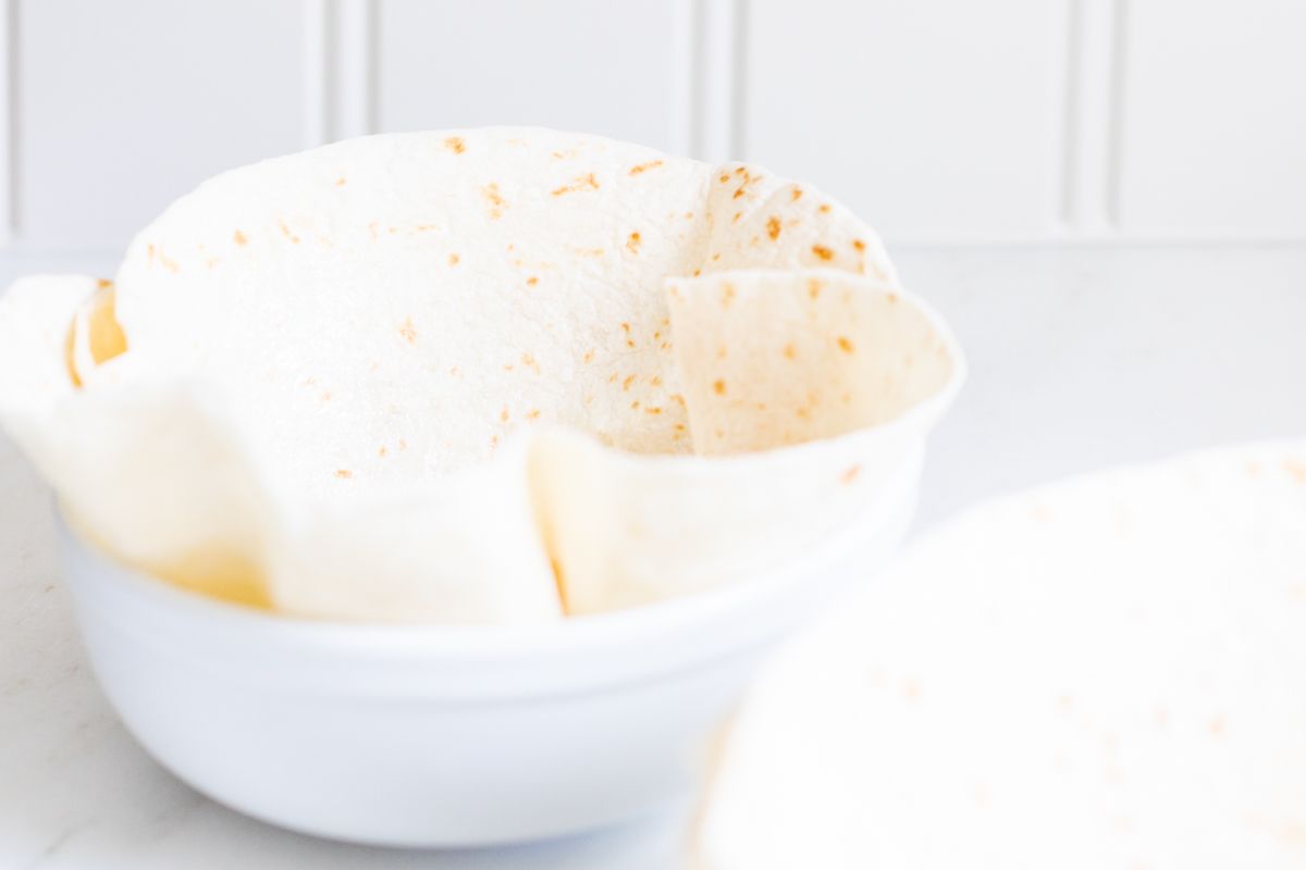 A flour tortilla folded into a bowl for a taco salad bowl recipe.