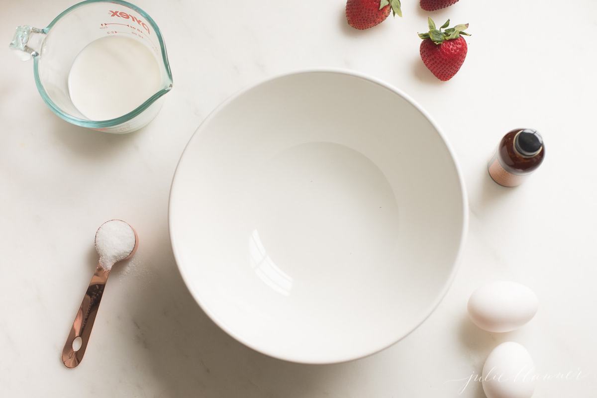 brioche french toast ingredients and a bowl laid out on a white countertop