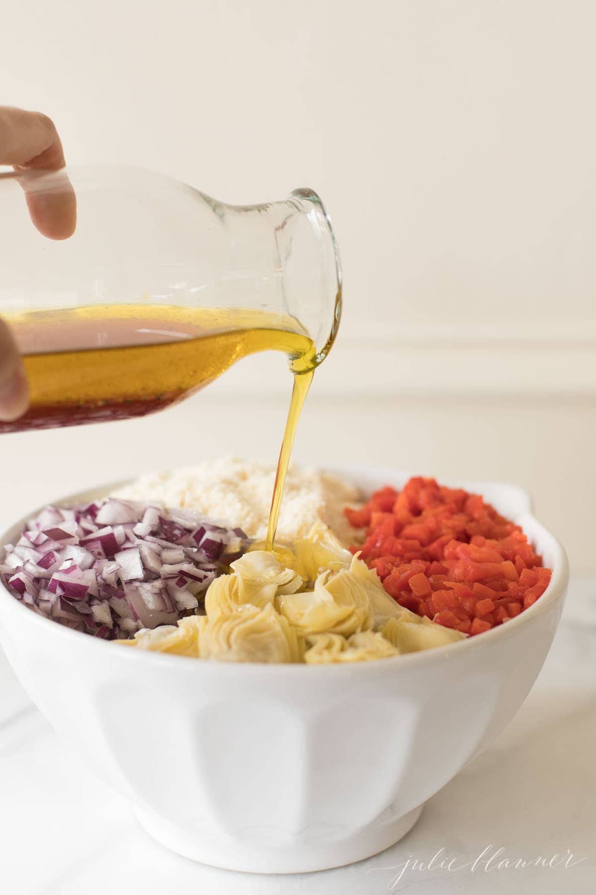Dressing being poured over the Italian pasta salad