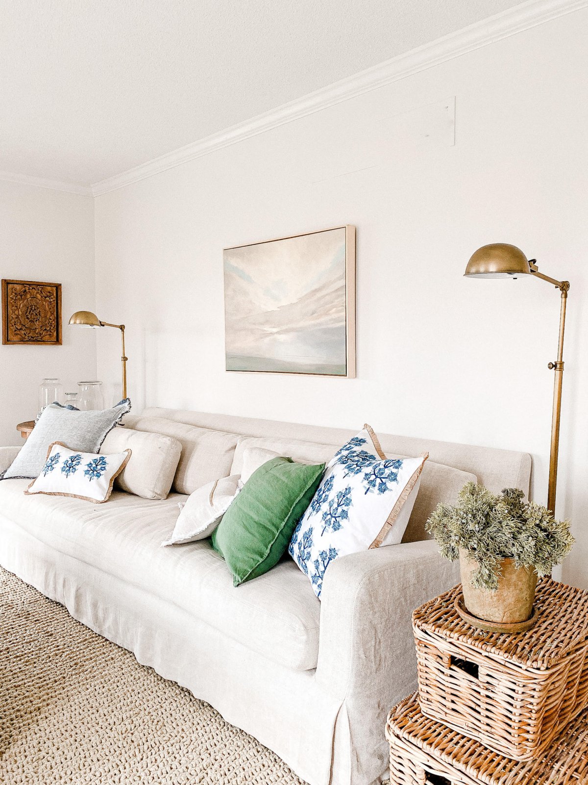 A living room with a white couch, wicker baskets, and a pet-friendly rug.