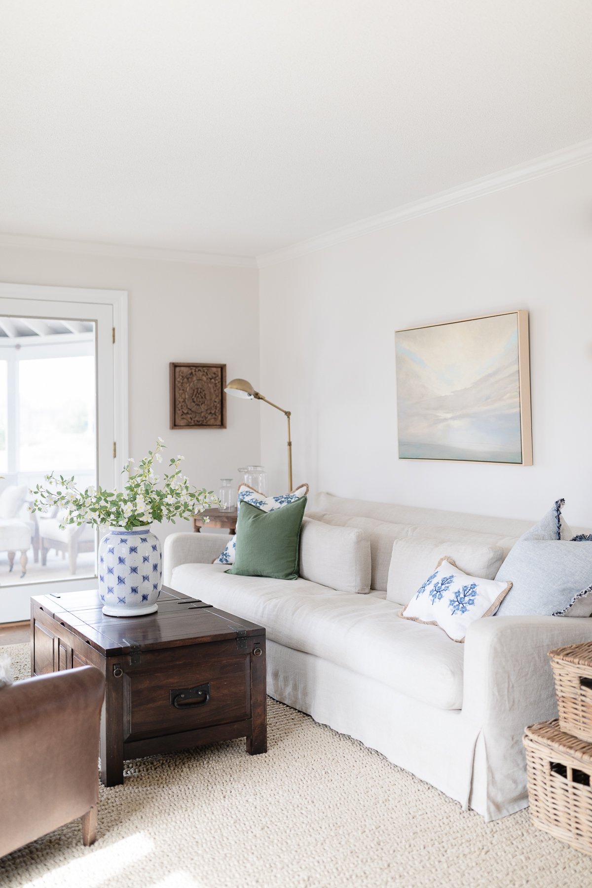 A white couch in a living room with a kid and pet friendly rug.