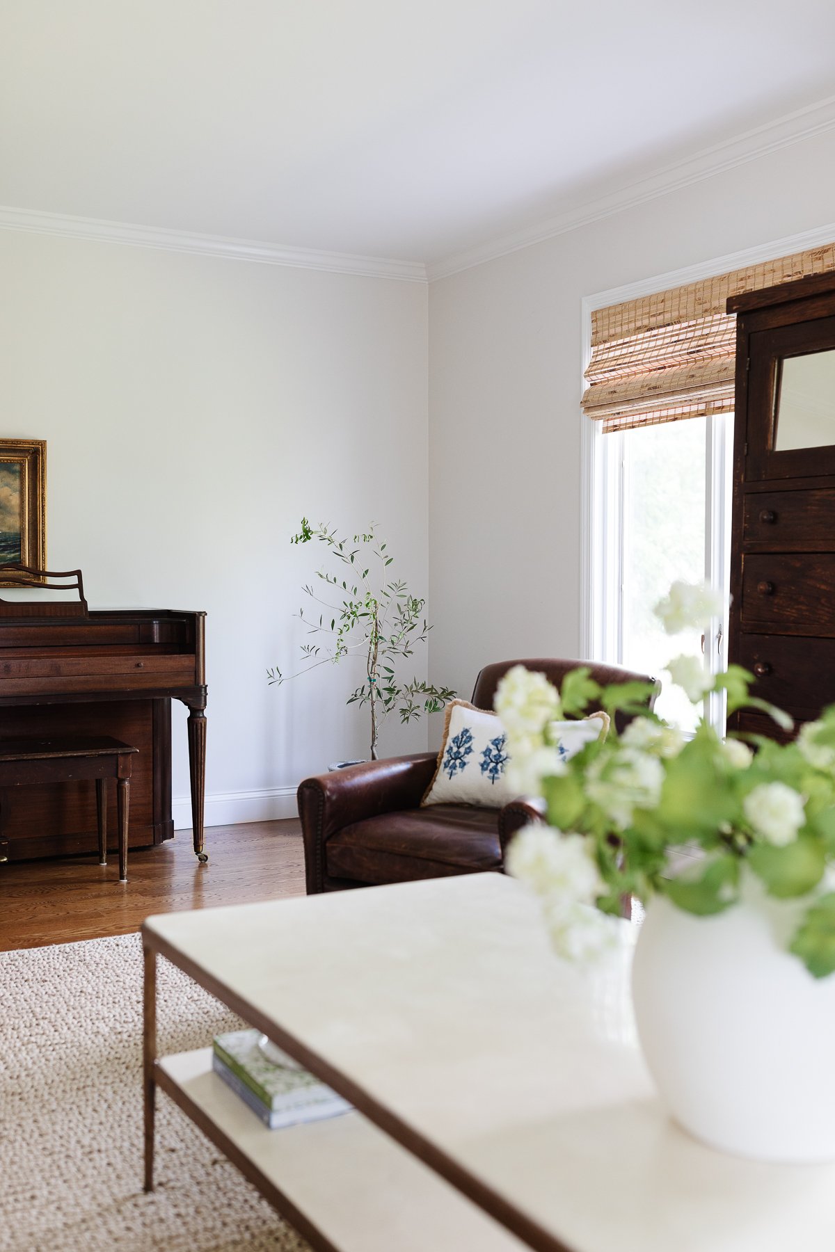 A living room with a piano and a kid-friendly rug.