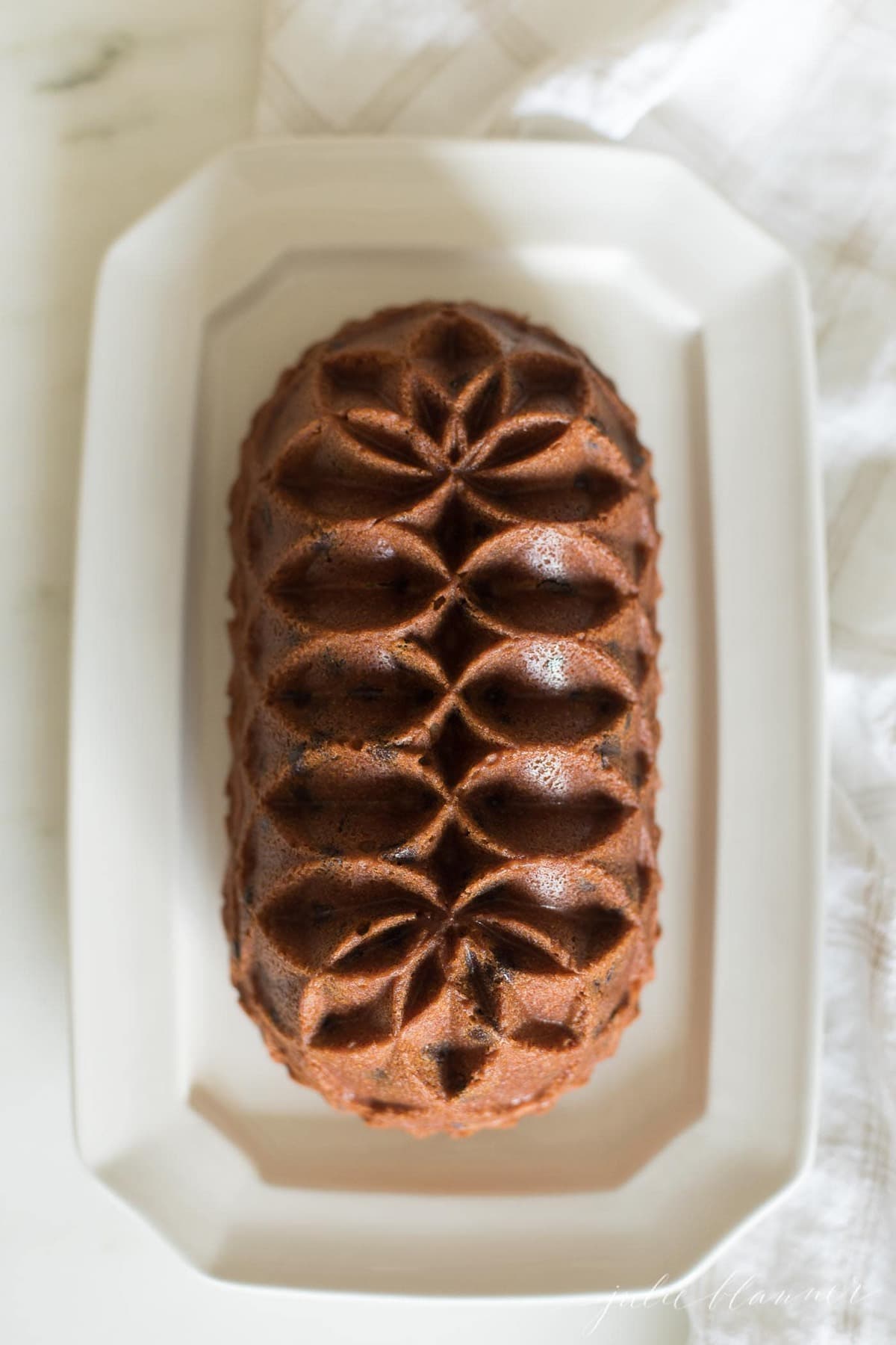 chocolate chip pound cake shaped in a decorative loaf, on a white platter