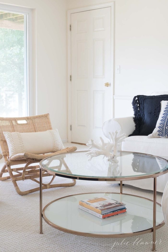 A modern living room with a round glass coffee table. 