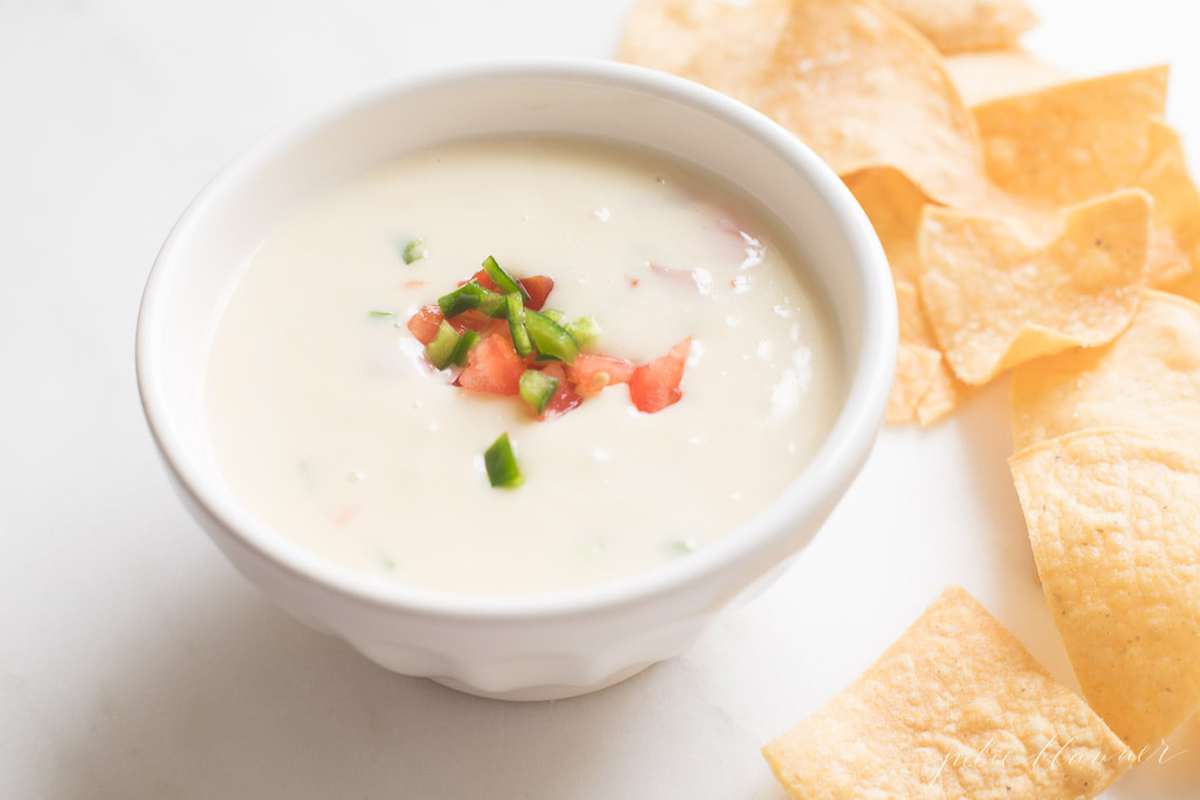 queso blanco dip in a white bowl with tortilla chips