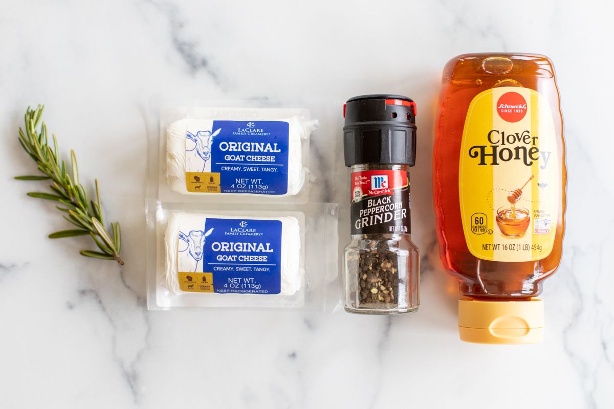 Ingredients for whipped goat cheese dip on a marble countertop.