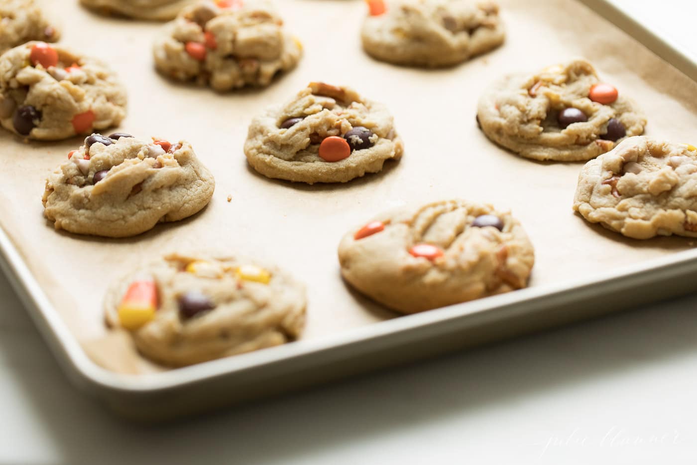 A baking pan covered in fresh baked cookies from a monster cookie recipe.