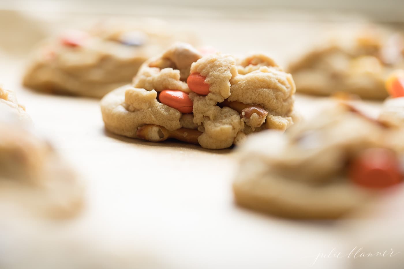 Close up of a gold baking sheet covered in candy cookies