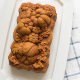 pumpkin pound cake on cream platter with blue checked napkin