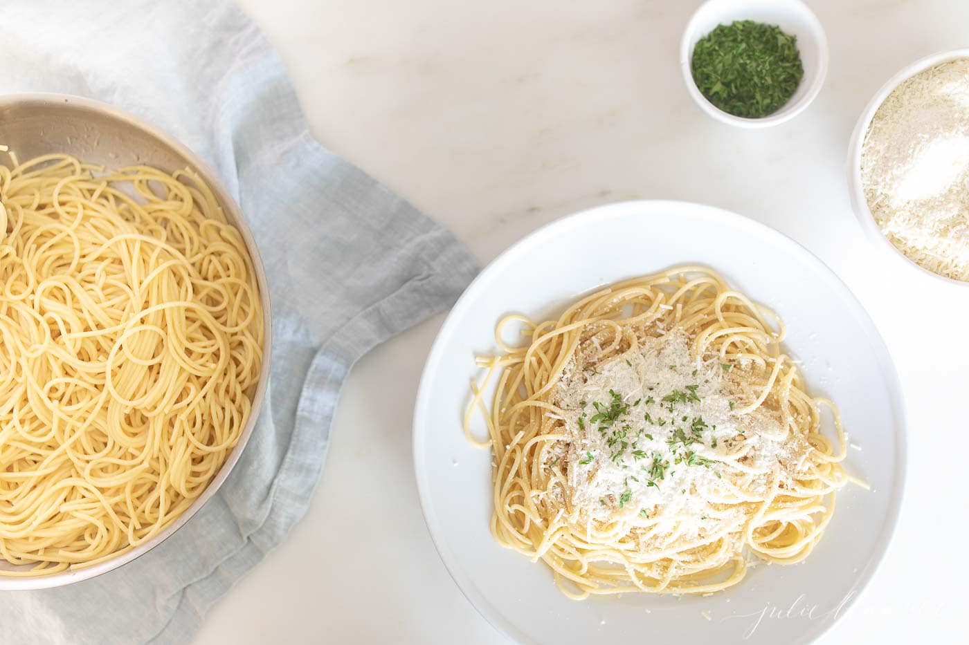 spaghetti on a plate sprinkled with mizithra cheese