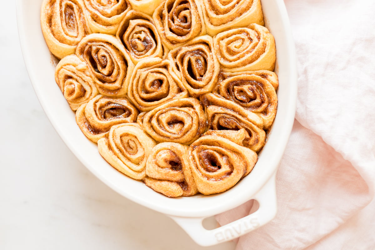 Cinnamon rolls made with crescent rolls in a white oval dish.