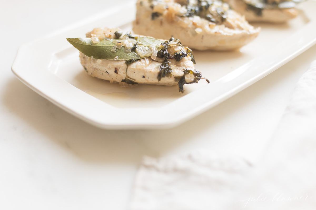 white wine chicken on a white platter.