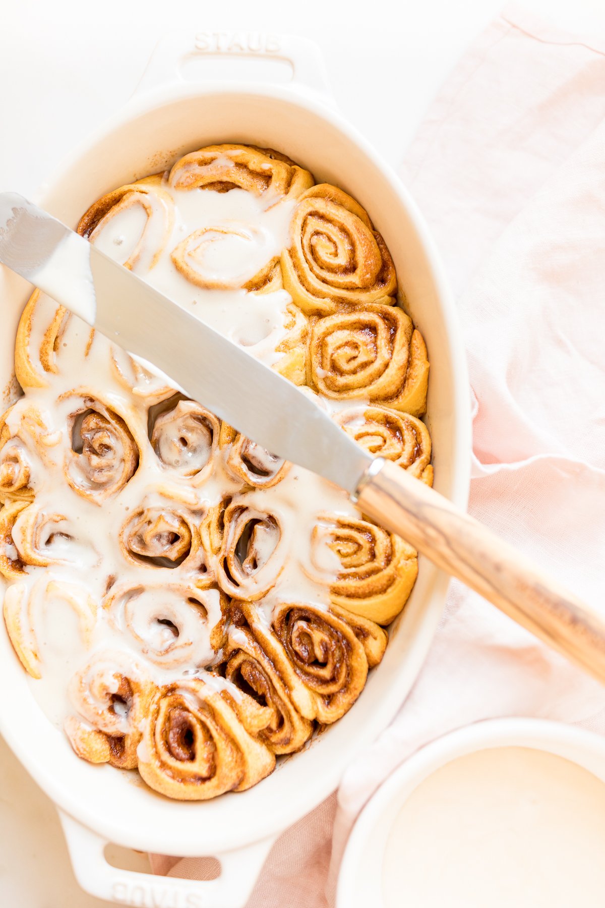 Cinnamon rolls made with crescent rolls in a white oval dish.