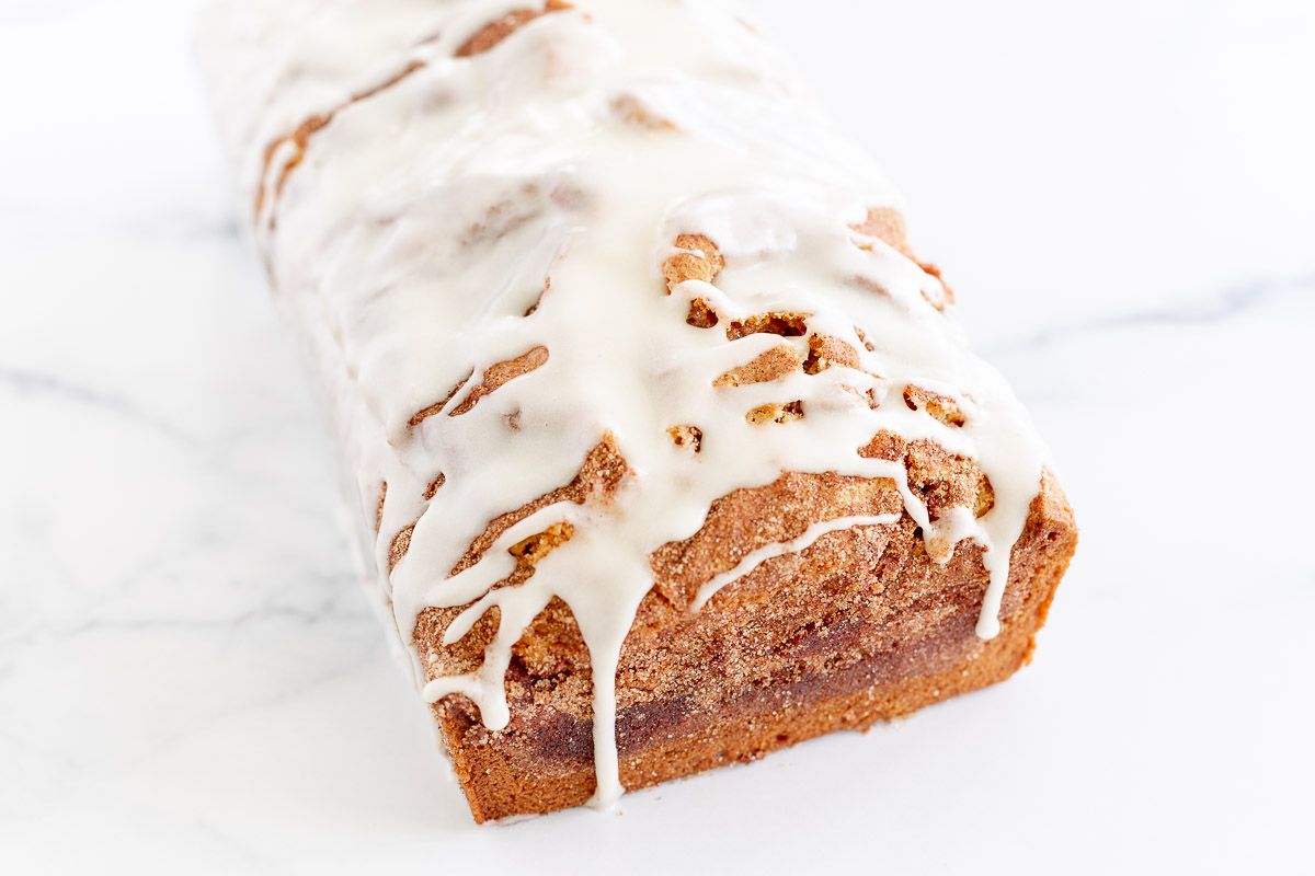 A loaf of cinnamon roll bread drizzled with icing