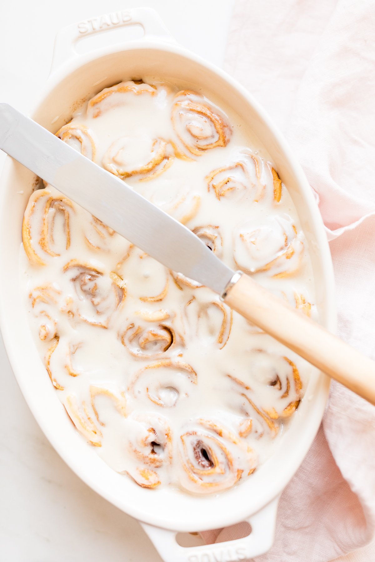 Cinnamon rolls made with crescent rolls in a white oval dish.