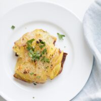 garlic smashed potatoes garnished with herbs