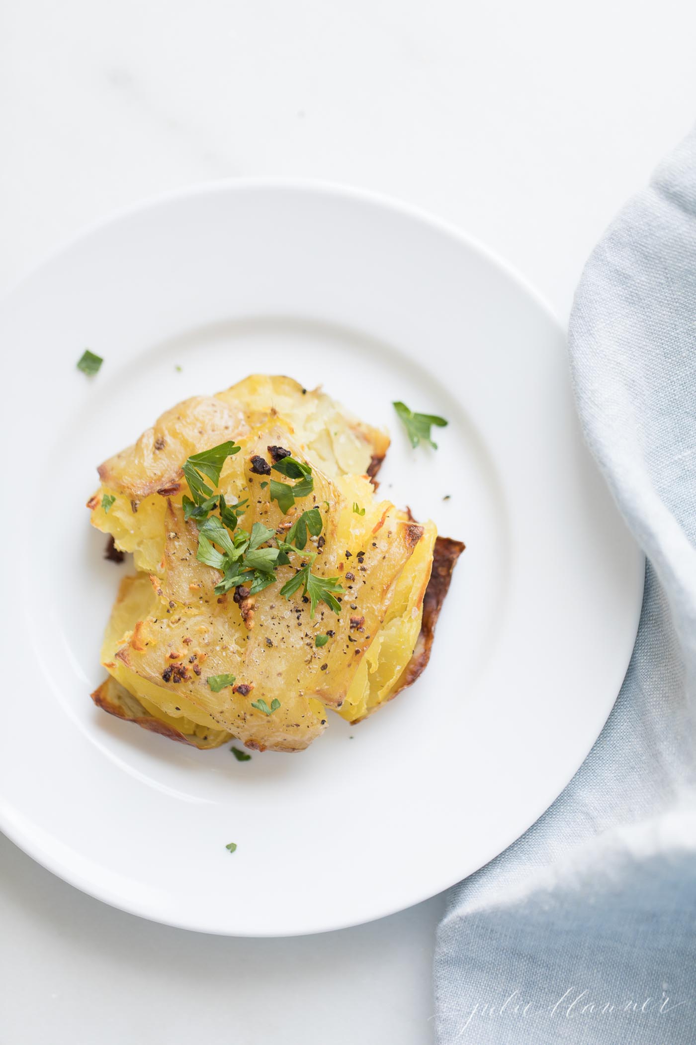 garlic smashed potatoes garnished with herbs