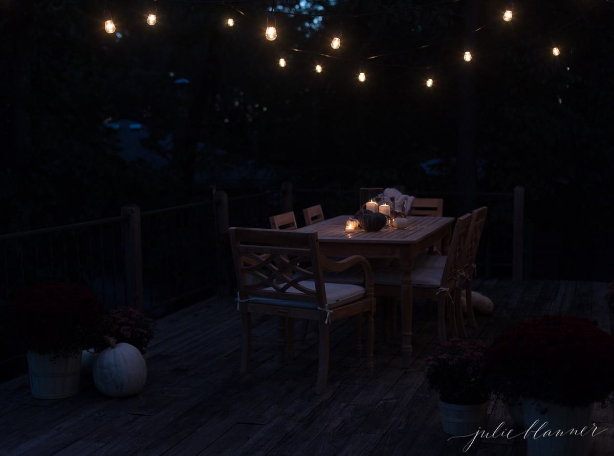 bulb lights over a table with pizza under the stars