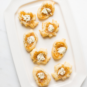 Caramelized shallot tarts on a white platter.