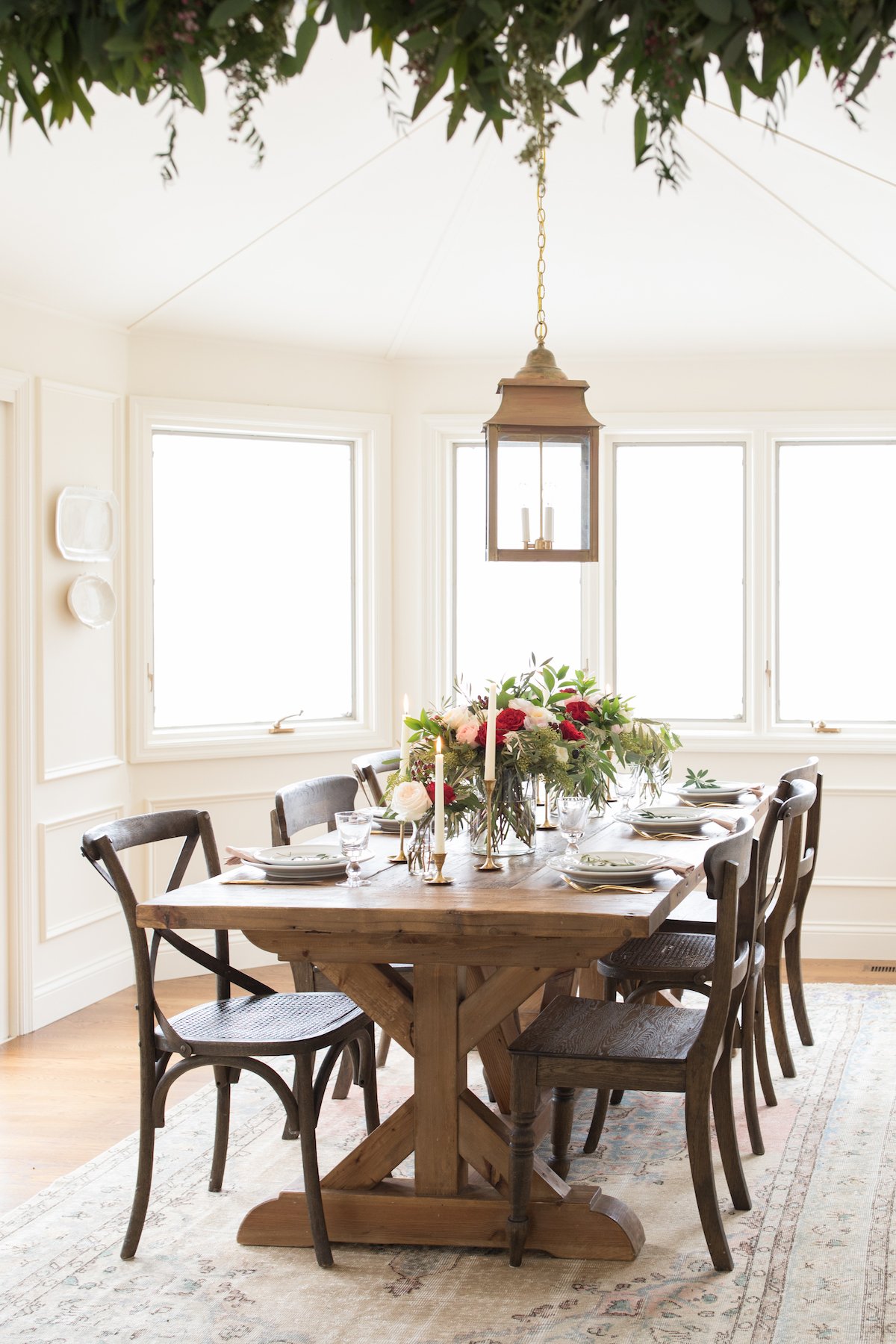 A dining room in a Christmas house, featuring a wooden table and chairs.