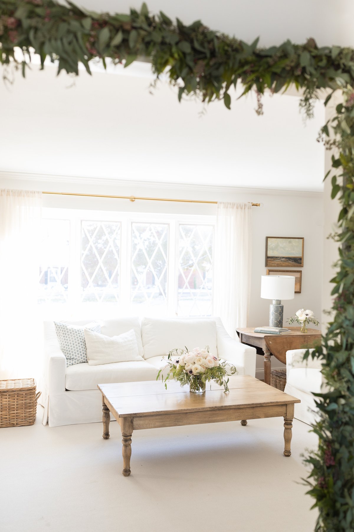 A white living room with a white couch and a white coffee table, perfect for a Christmas house.