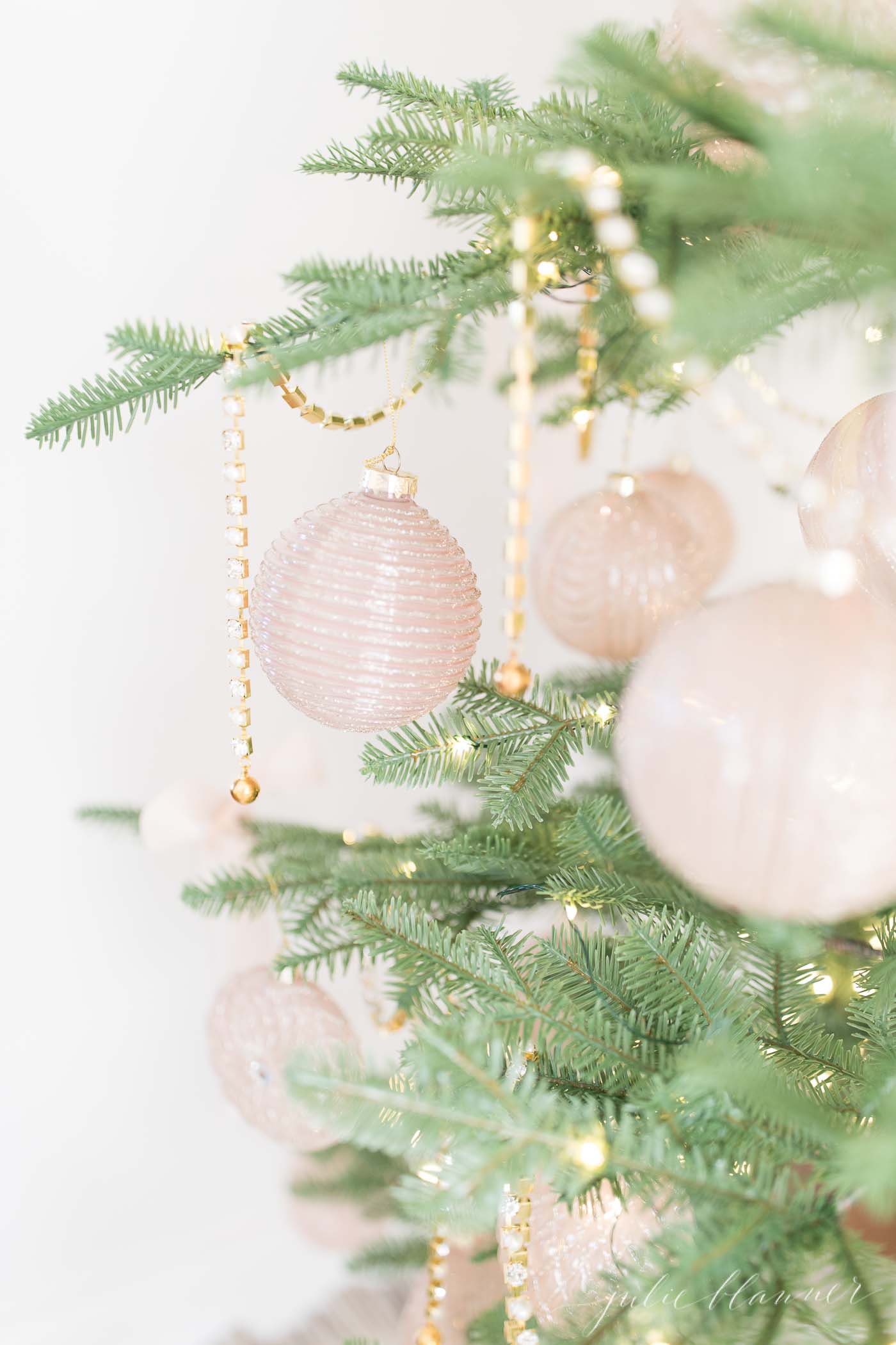 sparse christmas tree decorated in gold and pink ornaments