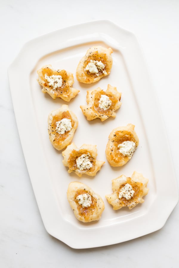 Caramelized shallot tarts on a white platter.