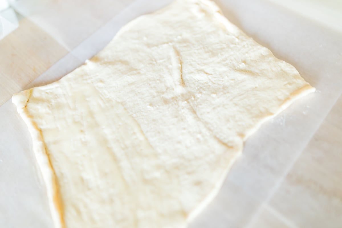 Sticky pecan rolls dough on a cutting board.
