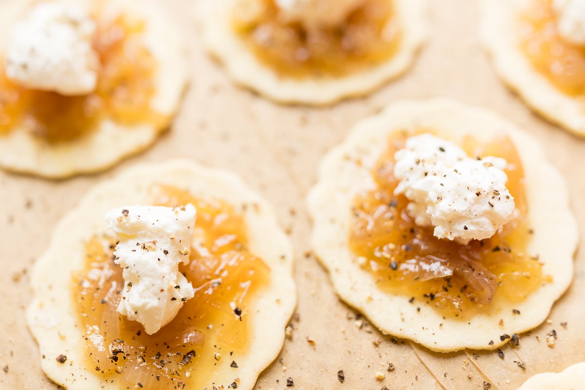 Small miniature onion tarts on a parchment lined pan.