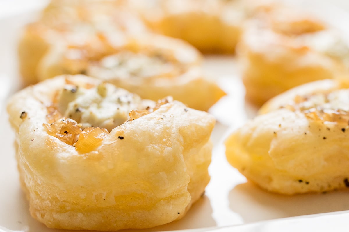 Caramelized shallot tarts on a white platter.