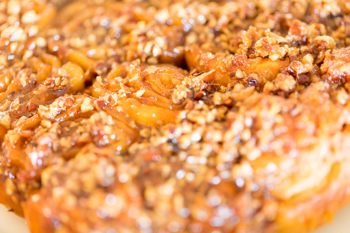 A close up of a piece of Caramel Pecan Sticky Rolls.