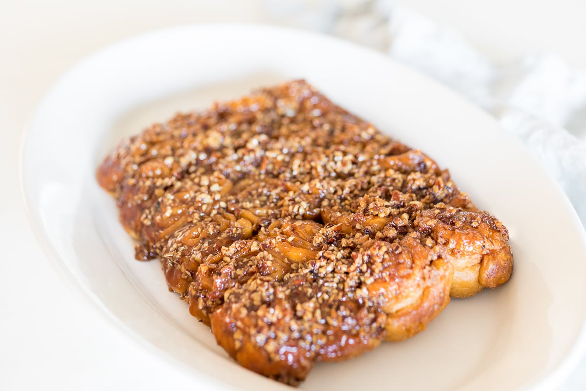 Caramel Pecan Sticky Rolls on a white platter.