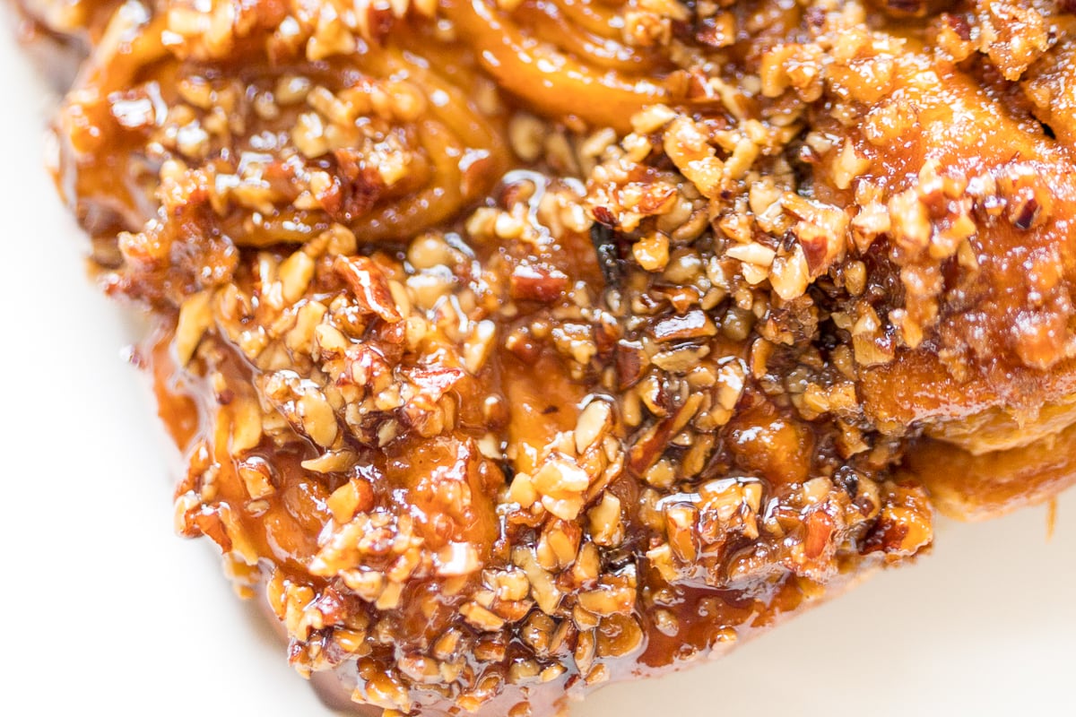 A close up of a piece of Caramel Pecan Sticky Rolls.