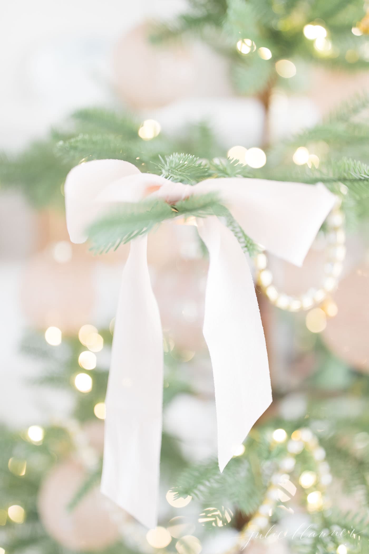 a sparse christmas tree tied with soft pink silk bows