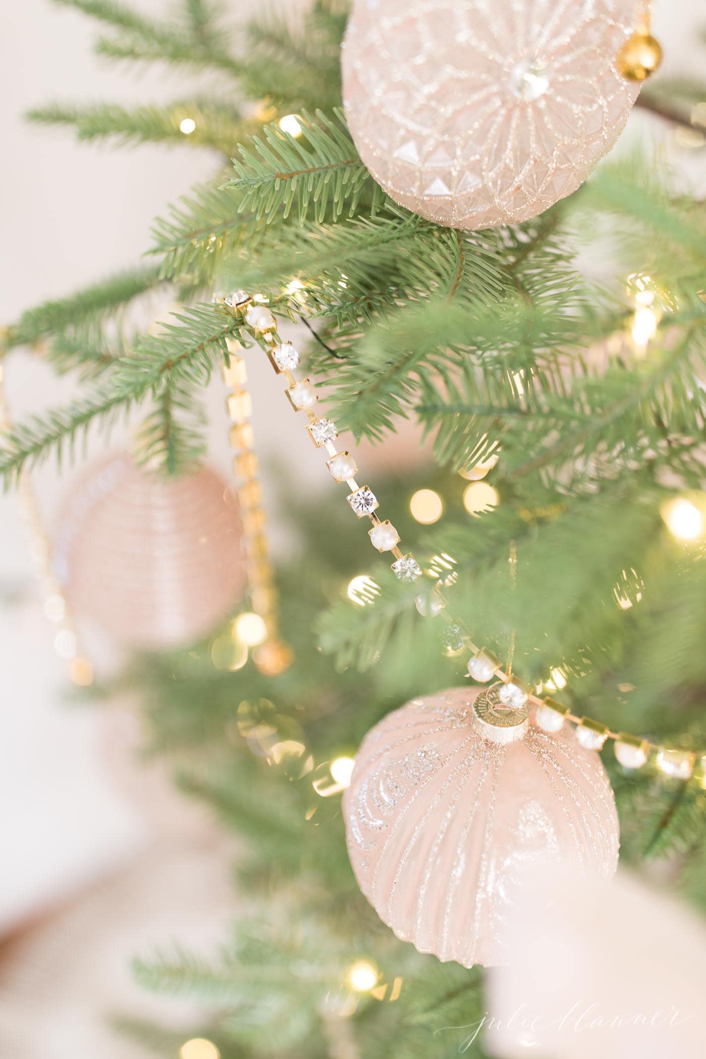 a sparse christmas tree with pink and gold ornaments