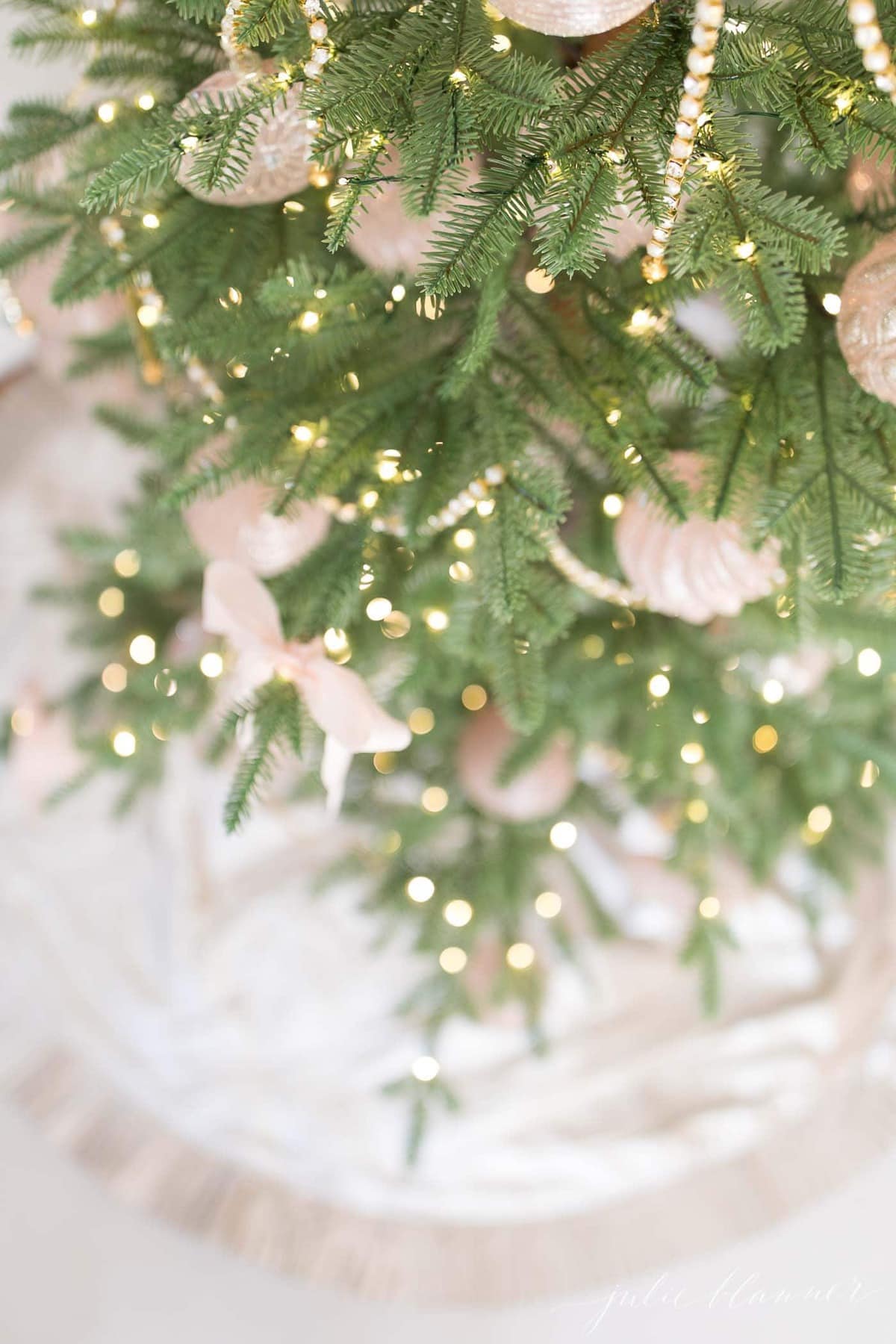 A sparse artificial christmas tree decorated in pink.