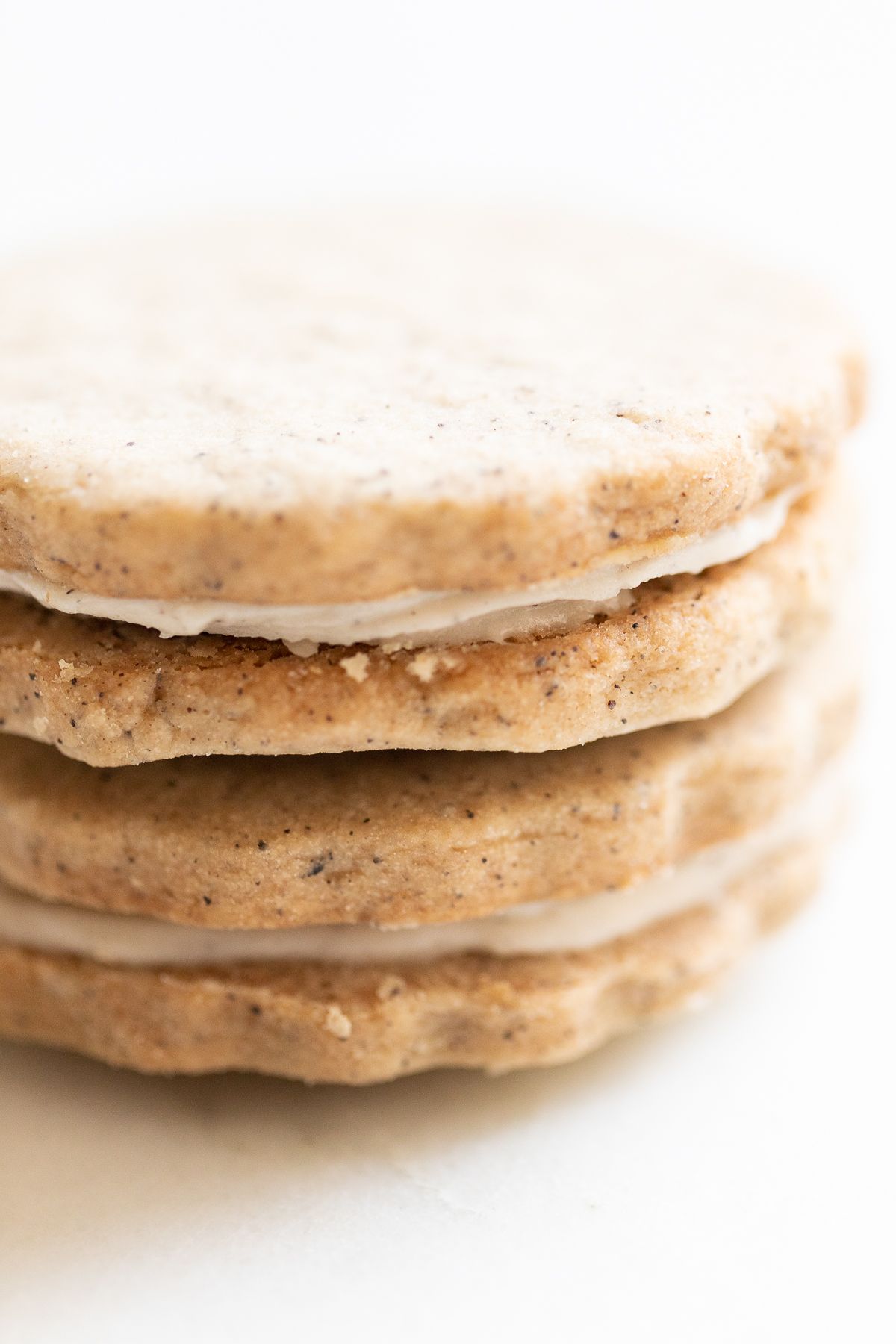 Espresso cookies stacked on a marble countertop.