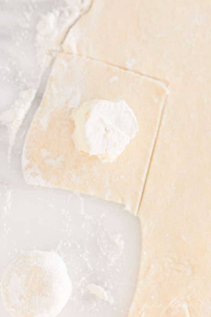 A piece of cheese on a square of puff pastry